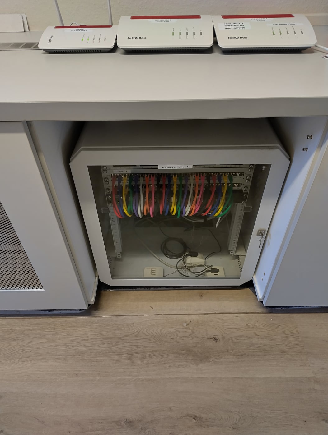In die Wand eingelassener Netzwerkschrank mit Router und Verkabelung.